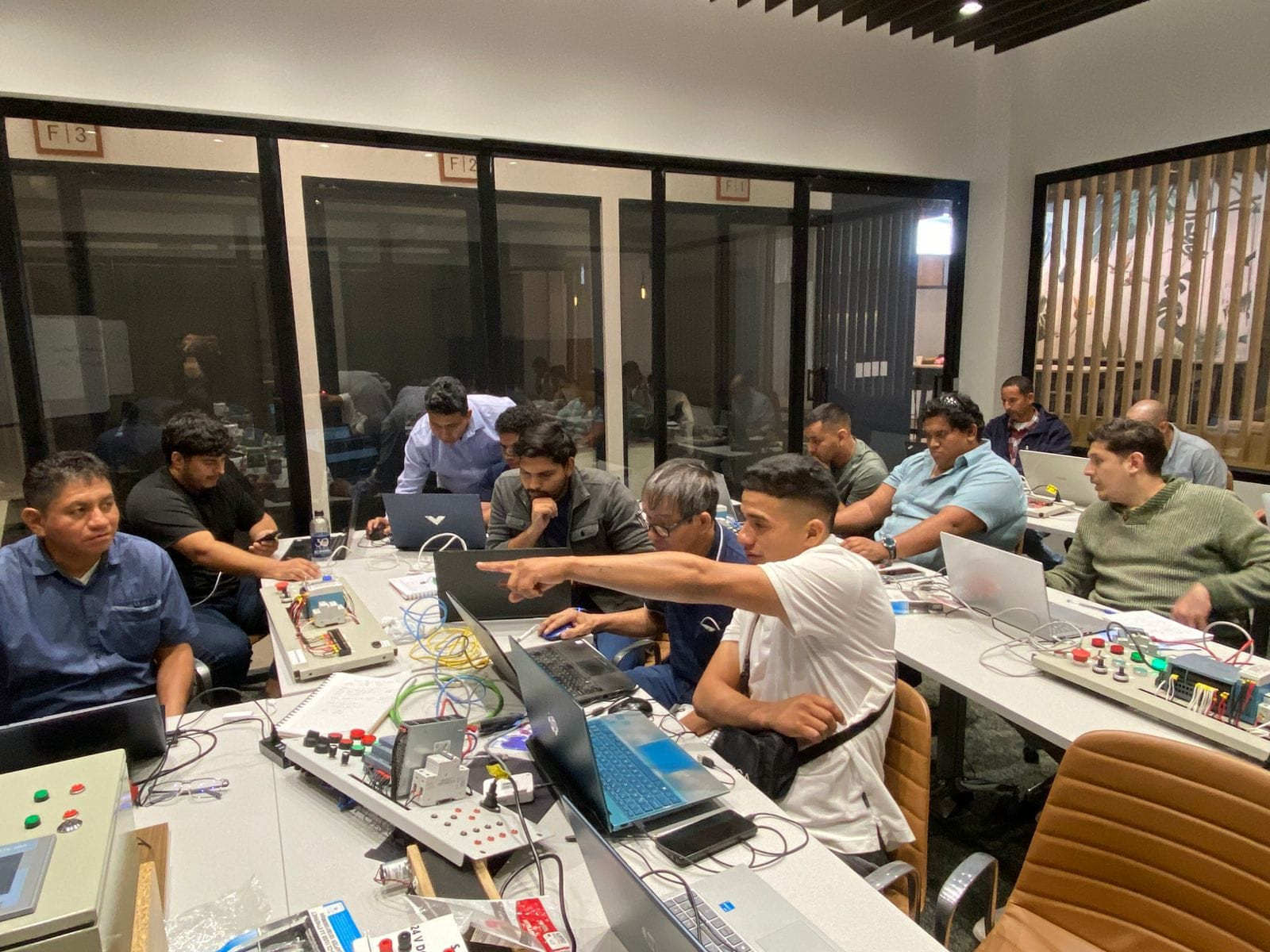 Estudiantes de CPT Mechatech realizando una práctica presencial de PLC, trabajando en programación y ejercicios aplicados con acompañamiento del docente.